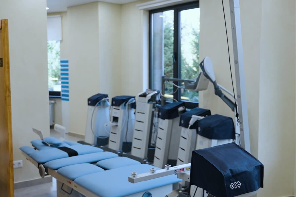 The equipment room: a treatment couch and BTL devices by the window